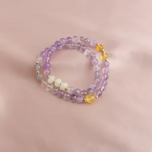 Macro detail of a double-strand gemstone bracelet with amethyst and sunstone beads