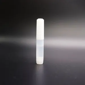 Detailed view of small white cylindrical plastic tube for nail glue and liquid cosmetic items