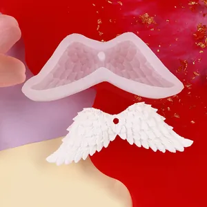 Detailed close-up of an angel wing silicone mold with a white feather wing
