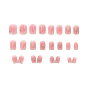 Full set of 24 blush pink gradient press-on nails with silver star patterns on white background