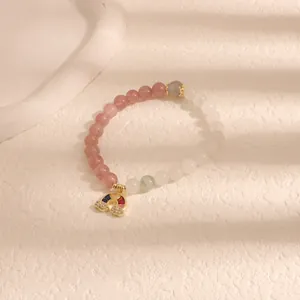 Elegante braccialetto di perline rosa e bianche con un ciondolo arcobaleno scintillante.