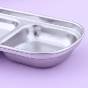 Close-up of a 2-compartment stainless steel sauce dish with a sleek metallic finish.