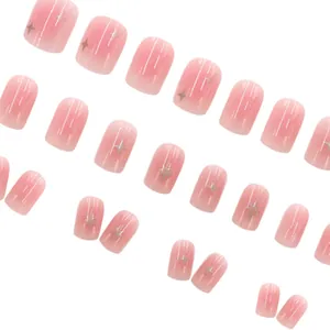 Detailed view of nude pink blush press-on nails featuring shimmer and golden four-pointed stars
