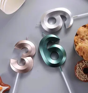 Detail shot of metallic number 3 and 6 birthday cake topper candles for party decor.