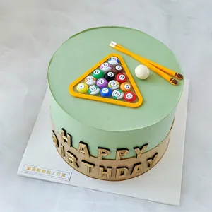 Detailed view of PVC billiard ball cake topper set placed on a green tiered birthday cake