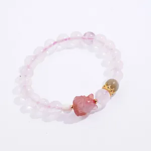 Close-up of Madagascar rose quartz bracelet with pink fox charm and crown detail