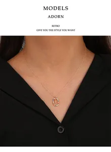 Detailansicht einer Goldkette mit buntem Zirkonia-Buchstaben-O-Anhänger an einem Model.