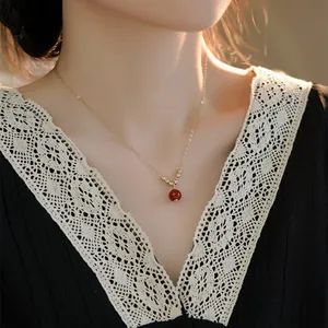 Primo piano di una collana vintage con ciondolo in agata rossa e catena in oro 14K