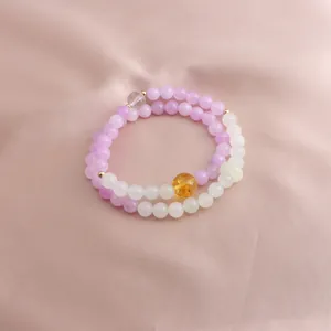 Detailed view of a double-strand lavender and white gemstone beaded bracelet on satin