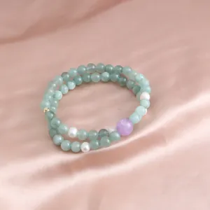Detailed view of a double-layered green jade bead bracelet with white pearls on silk