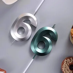 Close-up of metallic number 6 candles with faceted geometric design for cakes