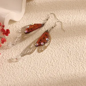 Detailed view of handmade cicada wing drop earrings with glittering rhinestones