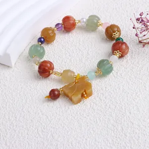 Makro-Detail eines natürlichen, bunten Jade-Perlenarmbands mit kürbisförmigen Steinen
