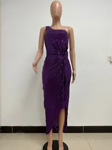 Detailed view of a purple sequined one-shoulder evening gown on a mannequin