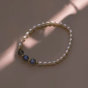 Close-up of a rice-shaped freshwater pearl bracelet with grey moonstone accents.
