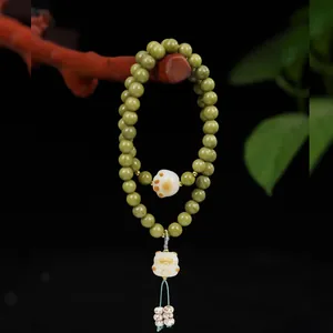 Vista dettagliata del bracciale in perle Alashan verde matcha con ciondolo zampa di gatto.