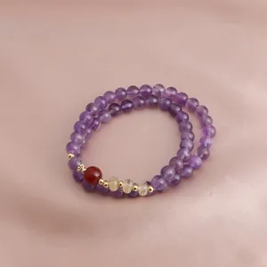 Macro view of a double-layered purple amethyst beaded bracelet with red agate accents