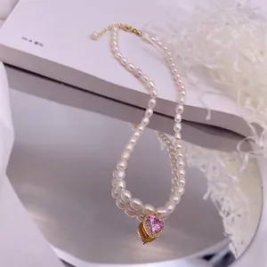 Detailaufnahme einer Süßwasser-Reisperlenkette mit funkelndem rosa Zirkonia-Herzanhänger.