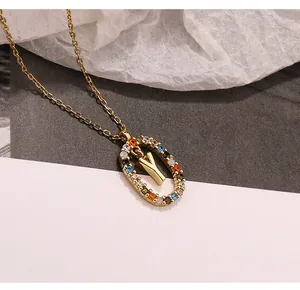 Detailaufnahme eines goldenen Halskettenanhängers mit bunten Zirkonia und dem Buchstaben Y