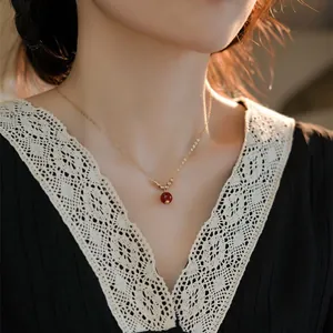 Primo piano di collana vintage in oro 14K con ciondolo in agata rossa su modella