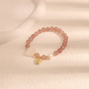 Vista dettagliata del bracciale di perle in quarzo fragola rosa con ciondolo portafortuna