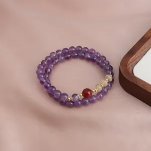 Close-up view of a double-strand purple amethyst bracelet with natural sunstone