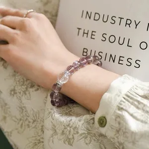 Detail eines Perlenarmbands aus natürlichem Amethyst und Bergkristall an einem Handgelenk