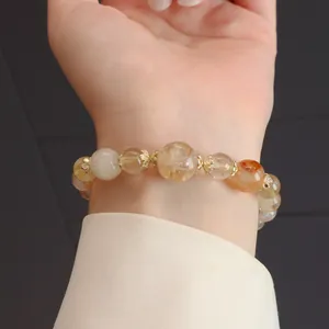 Nahaufnahme eines natürlichen mehrfarbigen Kristallperlenarmbands mit goldenen Akzenten