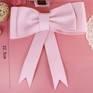 Détail d'un nœud rose décoratif pour gâteau avec dimensions 21cm sur 22.5cm