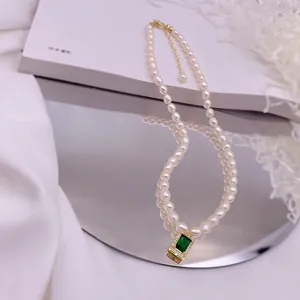Nahaufnahme einer Vintage-Süßwasserperlenkette mit elegantem grünem Zirkonia-Anhänger.