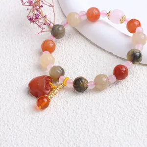 Makroansicht eines natürlichen Jinsi-Jade-Perlenarmband mit Kürbisperlen und Herzanhänger