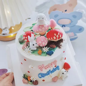 Vista detallada de adornos para tarta de goma suave con setas, conejos y texto de cumple.