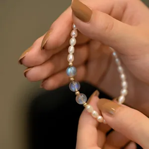 Close-up detail of rice water pearls and moonstone beads on a delicate elastic bracelet