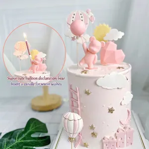 Vue détaillée de la figurine d'ours rose et du cœur sur un gâteau décoré.