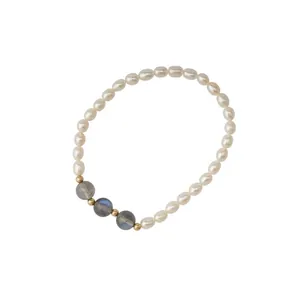 Detailed view of rice freshwater pearls and grey moonstone beads on an elastic bracelet