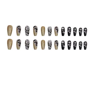 Detailed view of black and gold rose patterned mid-long coffin press-on nails.