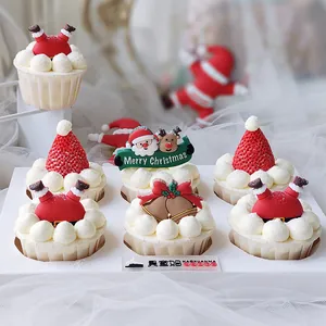 Primo piano di topper per cupcake natalizi con Babbo Natale e campanelle festive