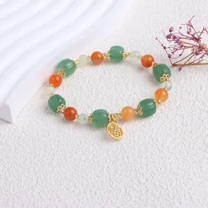 Detailansicht eines ethnischen Perlenarmbands aus goldener Seidenjade mit Kürbisperlen