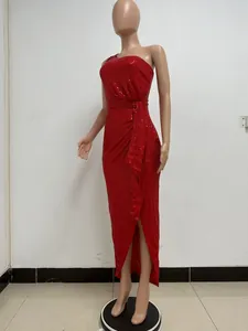 Detail shot of a red one-shoulder sequin dress with elegant waist tie and slit hem.