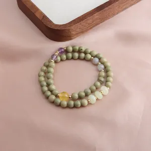 Detailed view of a double-strand Alashan jade bracelet with amethyst and sunstone beads.