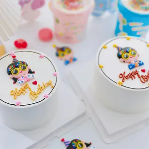 Detaillierte Ansicht einer süßen Kuchendekoration mit Mädchenfigur und Schriftzug.