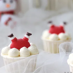 Detalle de adorno para pastel de Papá Noel en un cupcake con fondo festivo de Navidad