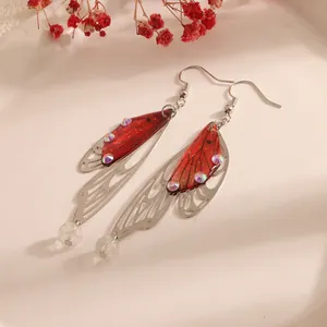 Close-up of elegant red cicada wing earrings with crystal accents and long tassels