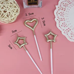 Dettaglio candele dorate a forma di cuore e stella per la decorazione di torte