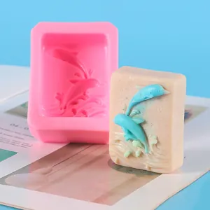 Detail view of pink silicone mold and finished soap with blue dolphin relief design.