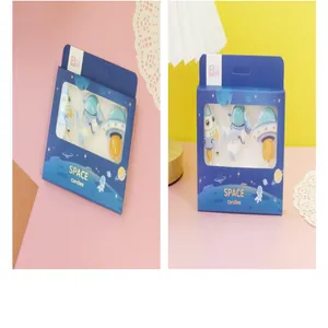 Astronaut and rocket shaped cake candles in a blue themed gift box packaging