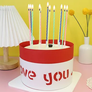 Detail view of twelve colorful twisted candles lit on a decorated birthday cake