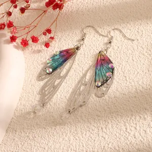 Close-up detail of elegant iridescent cicada wing earrings with sparkling crystal accents