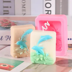 Close-up detail of 3D leaping dolphin relief silicone mold with finished handmade soaps