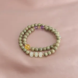 Detail of double-layered beaded bracelet with green Alashan and purple amethyst stones